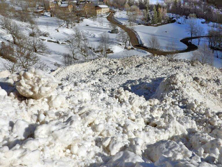 Blocs de neige de l’avalanche accumulés dans la pente, le hameau du Désert juste en contrebas