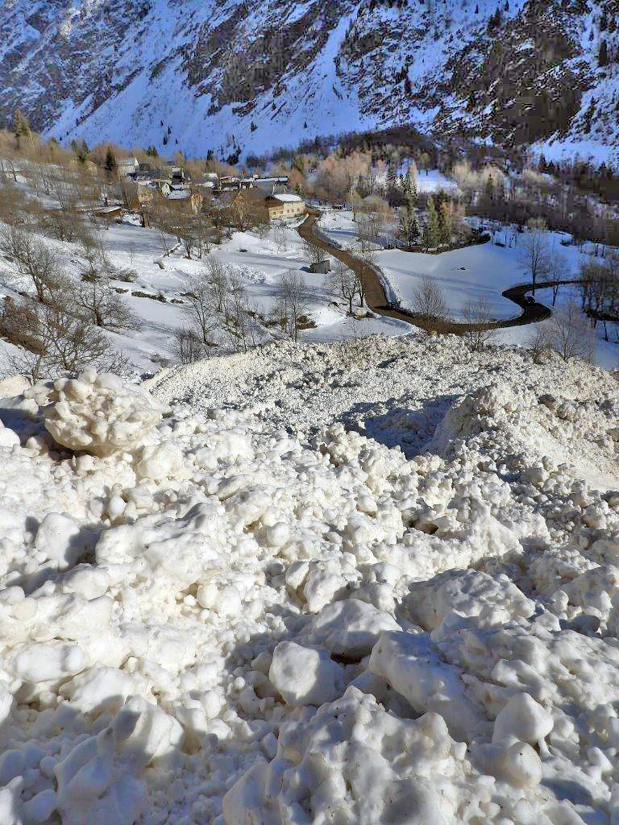Blocs de neige de l’avalanche accumulés dans la pente, le hameau du Désert juste en contrebas