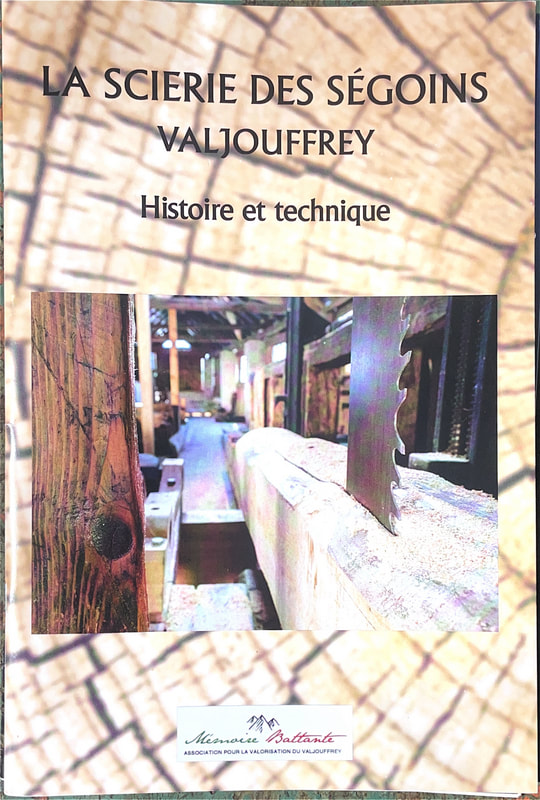Couverture du livret : la lame de la scie battante et son chariot, sur fond de bois débité
